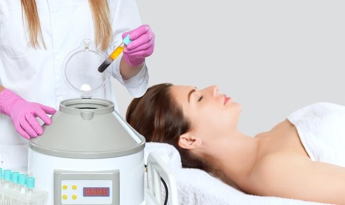 Doctora en consulta de estética con centrífuga y mujer esperando recibir  tratamiento facial con Plasma Rico en Plaquetas