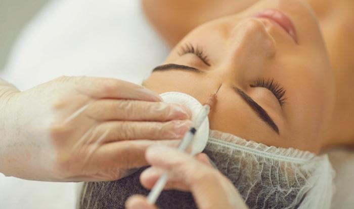 Paciente mujer recibiendo inyección de toxina botulínica en el rostro.