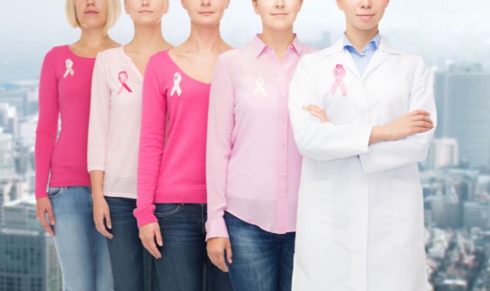 Mujeres usando lazo rosado para concientizar acerca del cáncer de mama. Test de cáncer de mama.