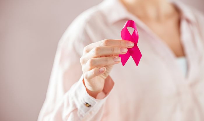 Test de cáncer de mama. Mujer con el ribbon rosado en la mano representando la lucha contra el cáncer de mama.