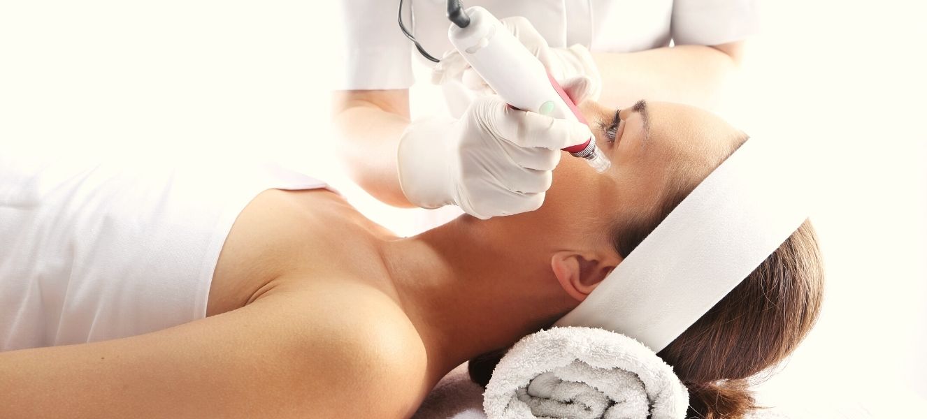 Mujer acotada recibiendo tratamiento estético microneedling con dermapen