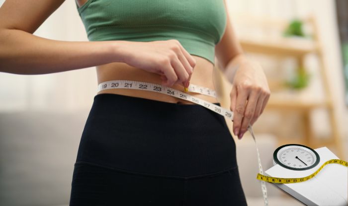 Inyecciones de Semaglutide: Mujer midiendo su cintura con cinta de medir para saber cuanto ha bajado de peso